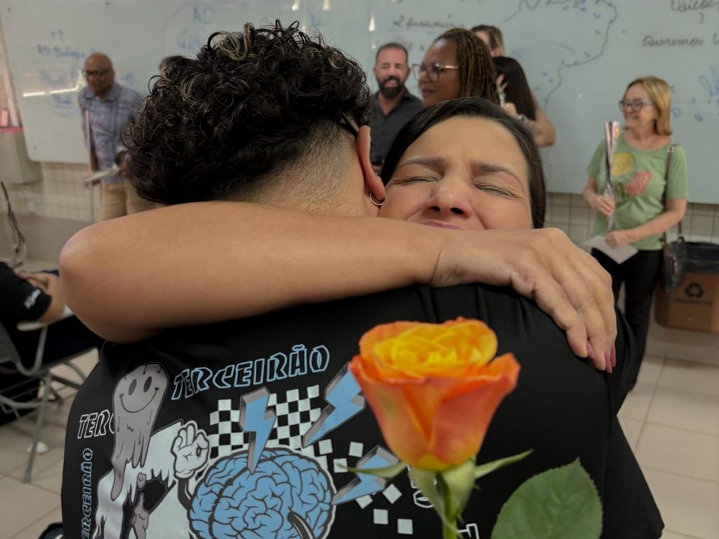 Mãe e estudante se abraçando no evento de despedida.