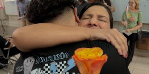 Mãe e estudante se abraçando no evento de despedida.